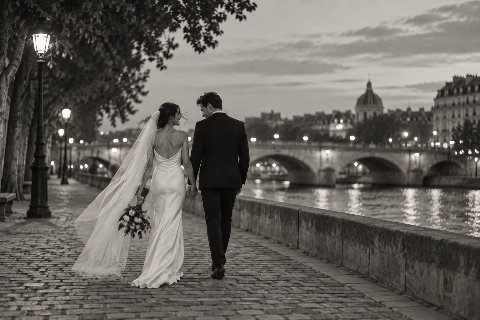 The couple walking beside the Seine at dusk